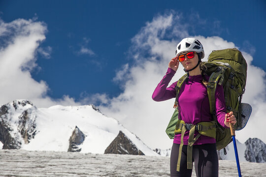 Young woman climber against the backdrop of beautiful mountains.