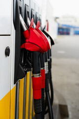 Petrol pump nozzles at service station for vehicle refueling.