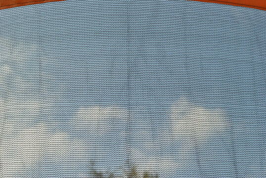 Safety Netting on Outdoor Trampoline in Close Up against Blue Sky 
