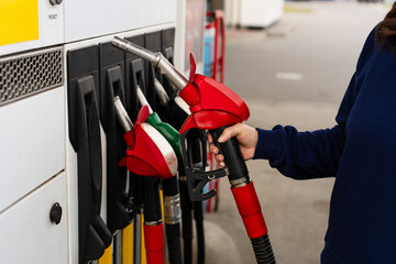 Hand holding gasoline nozzle at fuel station close-up. © Rabizo Anatolii
