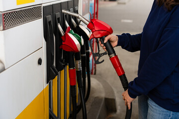 Close-up of refueling car with hand on fuel pump nozzle. © Rabizo Anatolii