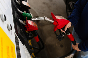 Petrol nozzle held in hand during automotive refueling process. © Rabizo Anatolii