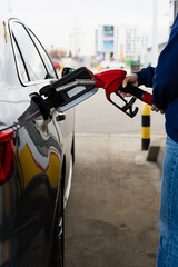 Fuel pump nozzle in car tank during refueling at station. © Rabizo Anatolii