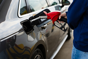 Refueling car with fuel pump nozzle at gas station. © Rabizo Anatolii