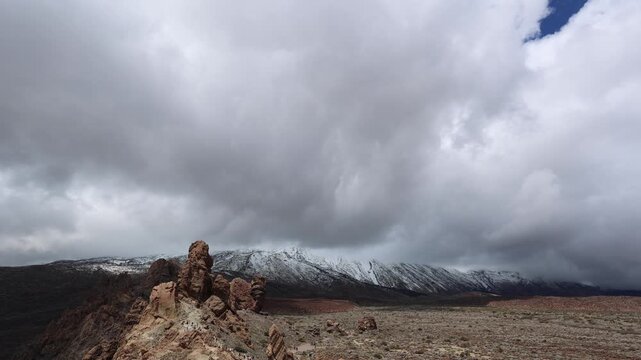 Snow covered Teide volcano landscape after storm Therese in Tenerife Canary Islands, dramatic clouds, volcanic terrain and winter conditions in subtropical island
