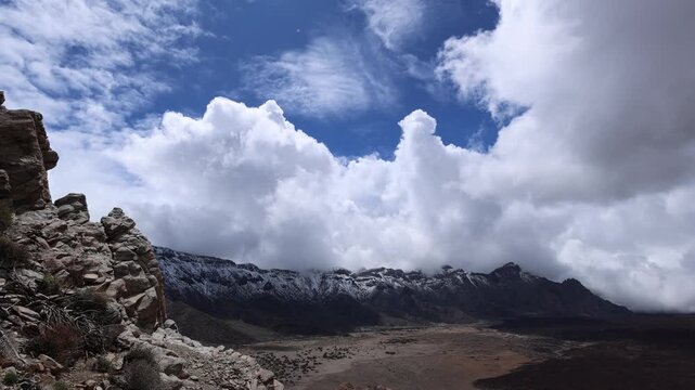 Snow covered Teide volcano landscape after storm Therese in Tenerife Canary Islands, dramatic clouds, volcanic terrain and winter conditions in subtropical island