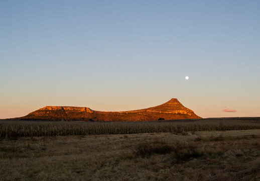 A hill in Clarens, South Africa, on a clear sunset evening, with the moon visible in the sky.