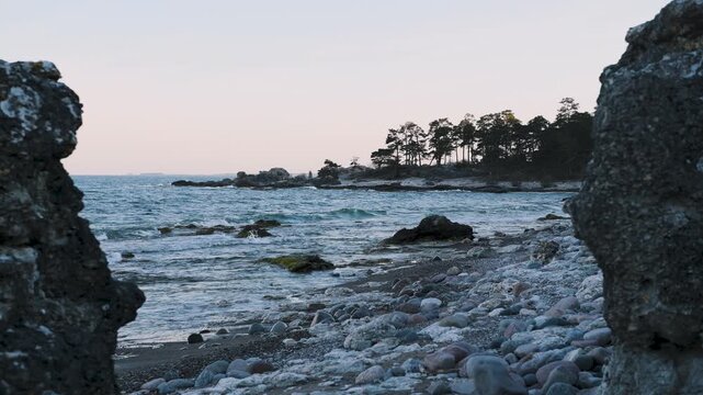 Waves hitting limestone coast framed between rauks at Folhammar in Gotland, Sweden