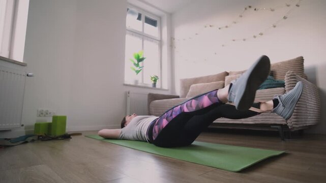 Girl Doing Fitness Exercises With Rubber Resistance Band, Doing Abs Exercises On A Floor