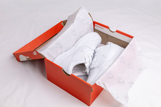 Kyiv. Ukraine. 03.18.2026 White nike sneakers in orange shoebox unboxing