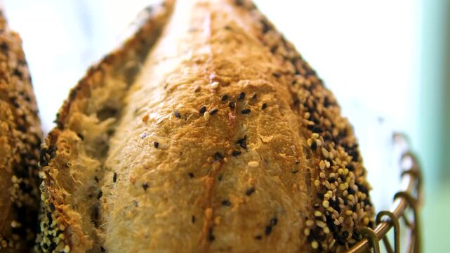 Fresh bread and buns with black and white sesame seeds on loaf bakery display near window shop morning baked goods