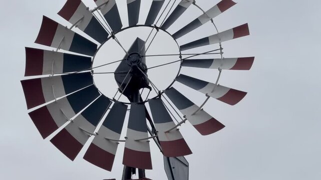Close up view of a rotating round pinwheel on weather vane with rotating red white and blue blades