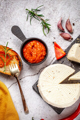 Soft cheese with red sauce garlic and herbs flat lay