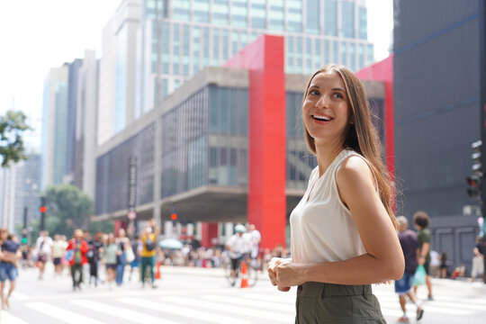Happy young woman smiling in front of MASP Museum on Paulista Avenue, Sao Paulo, Brazil