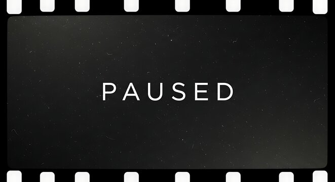 Vintage film frame with the word paused in white text on a dark textured background.