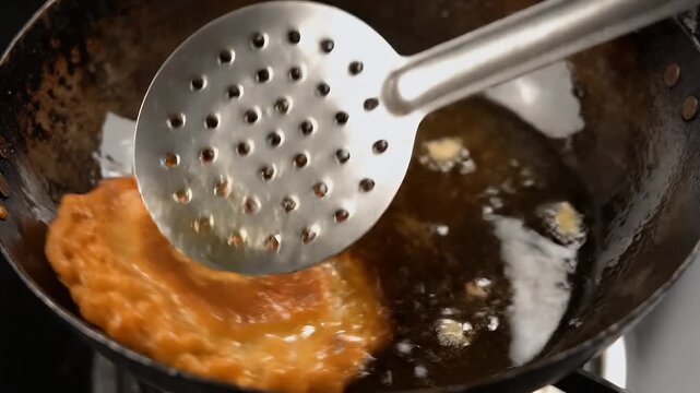 Close Up Top Down View Of Golden Brown Malpua Frying In Hot Ghee In A Wok With Bubbles Rising Traditional Indian Dessert Preparation