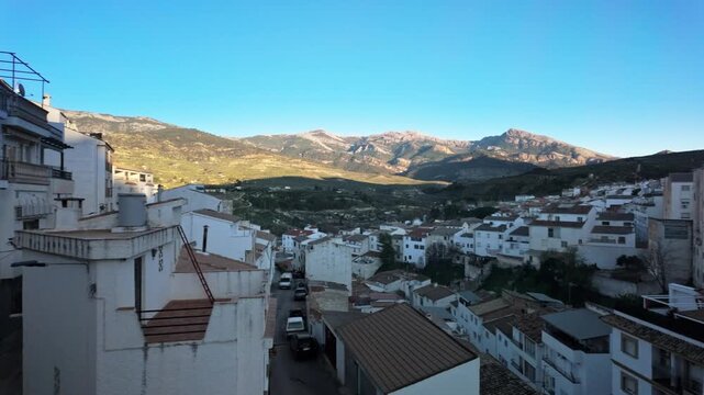 Experience the breathtaking beauty of Quesada, a charming white village in Andalusia, Spain. Overlooking stunning mountains and lush olive groves under a vibrant blue sky.