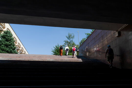 Silhouetted pedestrians walk up stairs from the Mustaqillik Maydoni subway station toward bright sunlight and blue sky, Tashkent (Toshkent), Uzbekistan (O'zbekiston)
