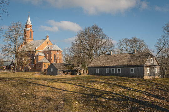 The new neo-gothic church with a traditional wooden house, Kernave, Lithuania, the medieval capital of the Grand Duchy of Lithuania, UNESCO world heritage, a tourist attraction