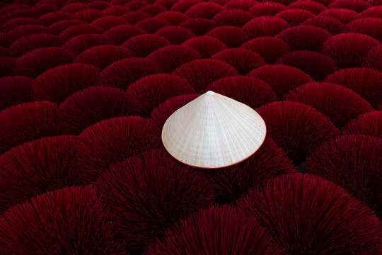 Traditional conical vietnamese hat non la on red incese sticks
