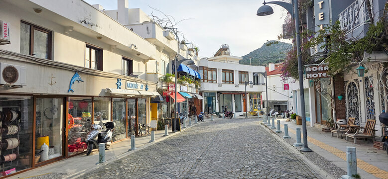 Cobblestone street lined with shops and cafes in charming coastal town