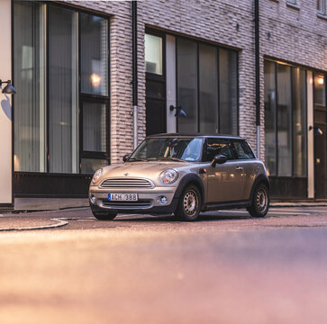 Gothenburg, Sweden - november 30 2025: 2007 Mini Cooper photographed in warm evening street lighting.