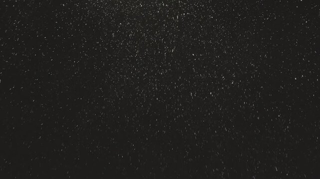Street light illuminating falling snow during snowstorm at night. Realistic falling snow effect against a dark night sky, ideal for compositing winter scenes, creating a serene and magical atmosphere.