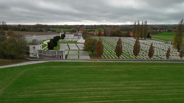 Drone shot of Tyne Cot Memorial, showing the curved wall and headstone rows of fallen WWI soldiers in the Flanders fields, Belgium.