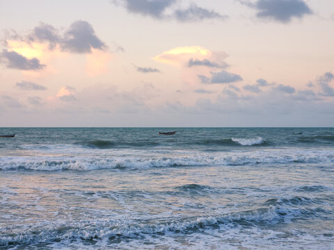 Early Morning Fishing Boats on the Horizon with Pastel Sunrise Sky and Breaking Waves. Praia do Prea, Ceara, Brazil