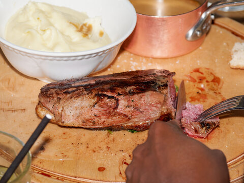 Pi&egrave;ce de boeuf grill&eacute;e d&eacute;coup&eacute;e au restaurant avec pur&eacute;e, plat gourmand pour amateur de viande