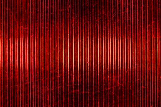 Closeup of old car tail light lens with red glowing vertical ridges and scratches, abstract automotive texture for background design, retro transport and industrial concepts