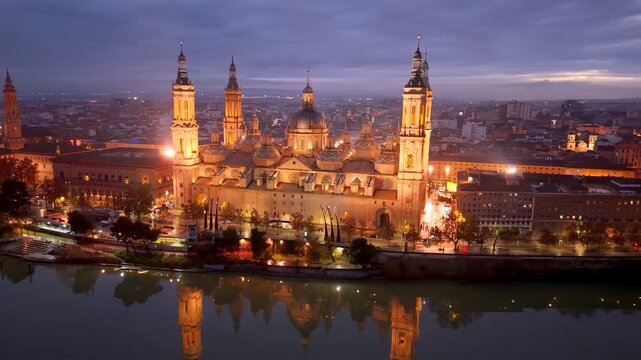 Aerial View Capturing Sunset Glow Illuminating Cathedral Domes And Tranquil River Reflections. Zaragoza. Spain 