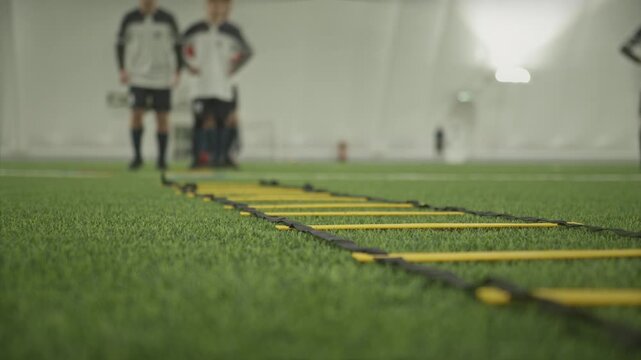 soccer players doing agility ladder drills during training