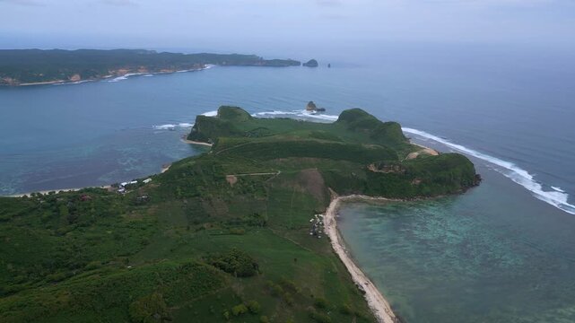 Aerial Coastal Village And Coral Flats,Long Sandy Ribbon Curving Along Shallow Turquoise Shelf, Scattered Houses And Vegetation,Reef Patterns Visible Through Clear Water, Katil beach,Lombok,Indonesia