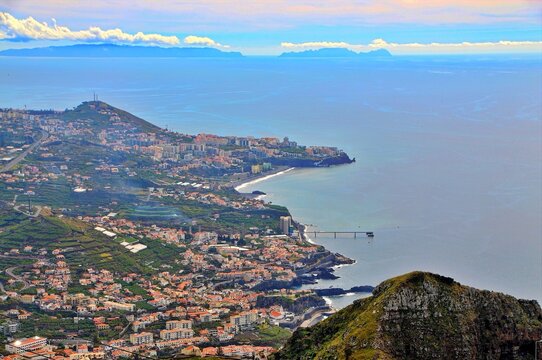 Coastal City Vista: A breathtaking panoramic view of a vibrant coastal city nestled along the azure sea, with rolling hills and distant islands painting a picturesque scene.