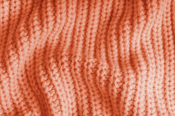 Close up, macro of crumpled orange knitted fabric with visible wrinkles, folds and soft waves. Soft wool texture with detailed stitches and creases, natural textile background, fashion, design © katyamaximenko
