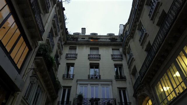 Elegant courtyard with balconies and warm window light Paris France