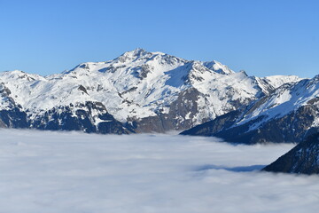 Obraz premium Snowcapped French alps under sea of clouds by winter