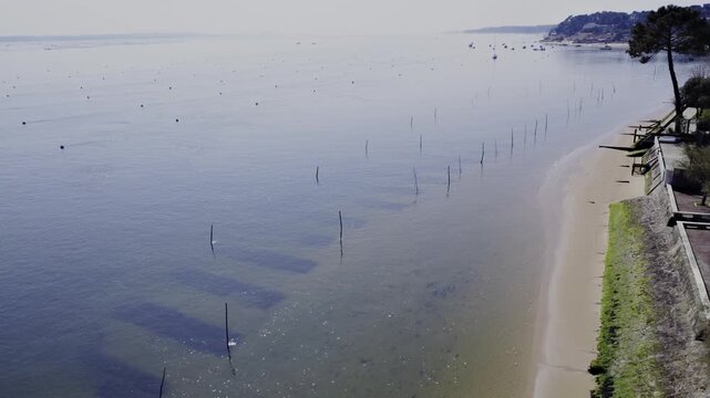 Drone view over an oyster farm in Grand Piquey village Cap Ferret, revealing structured oyster beds at low tide within Arcachon Basin shellfish farming landscape in southwest France