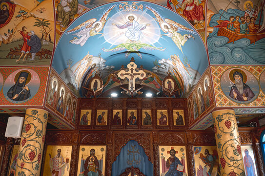 Agios Nikolaos church interior with detailed Byzantine art, frescoes, and a wooden iconostasis. Protaras