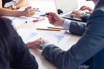 A business leader at a table looks at a chart