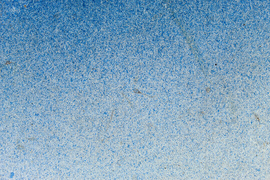 Abstract blue spray paint background texture with gradient effect on white surface
