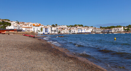 Pebble beach and waterfront houses in Cadaques on sunny day, Catalonia, Spain © pillerss
