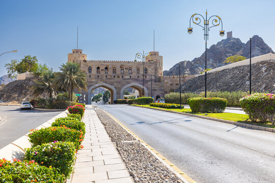 Muscat, Oman &ndash; December 28, 2025: Historic Muscat Gate with traditional stone architecture and arched entrance at the old city, surrounded by mountains under clear blue sky.