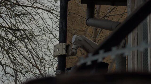 Aged outdoor security camera. Longterm outdoor security camera with weathered housing and surrounding bare branches