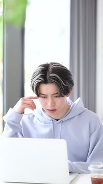 大学のキャンパスや予備校、高校生の塾など授業をうけてわからなくて頭を抱える悩む困る学生の男性のイメージ「単位やばい～」や「受験大変のイメージ」の縦動画