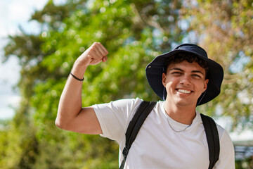 Fototapeta premium Young man showing bicep during outdoor hiking