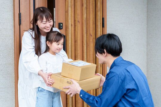 荷物を受け取る女の子とお母さん