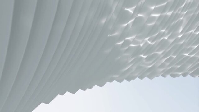 Close-up view of a white pleated shade with a textured surface against a light background.