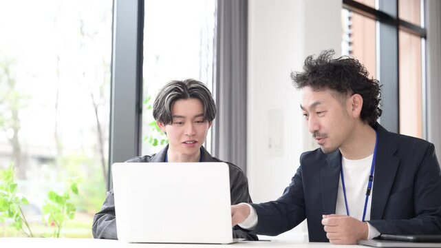 会社の仕事中に上司に励まされる新卒などの新入社員の爽やかなイメージ　その調子！仕事頑張ってね！OJTで先輩に指導を受ける若手社員の成長と教育のビジネスシーン動画